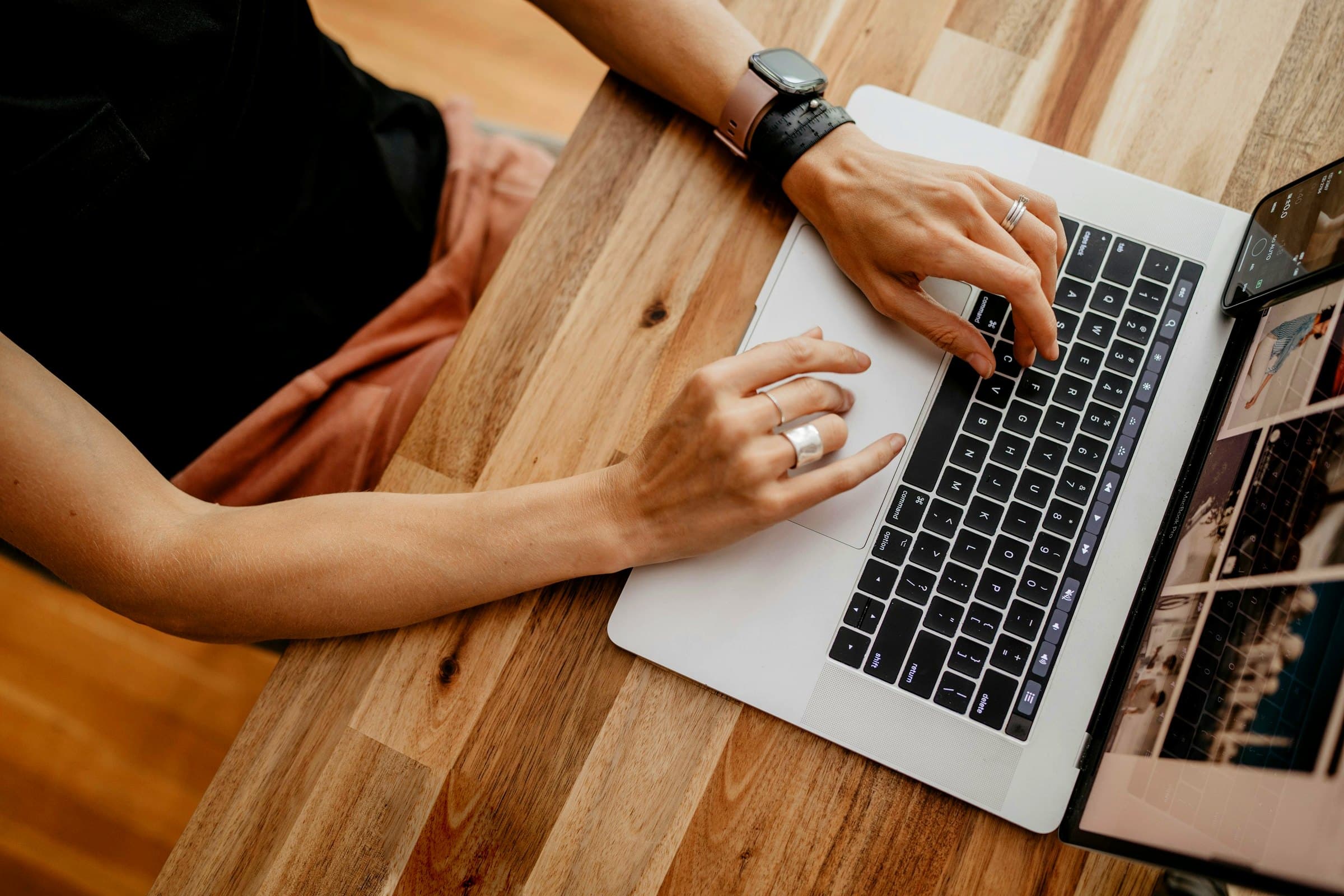 A person typing on a laptop — the creative engine producing brand-locked variants.
